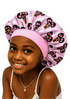 Child wearing a pink satin bonnet with afro girl print on a white background