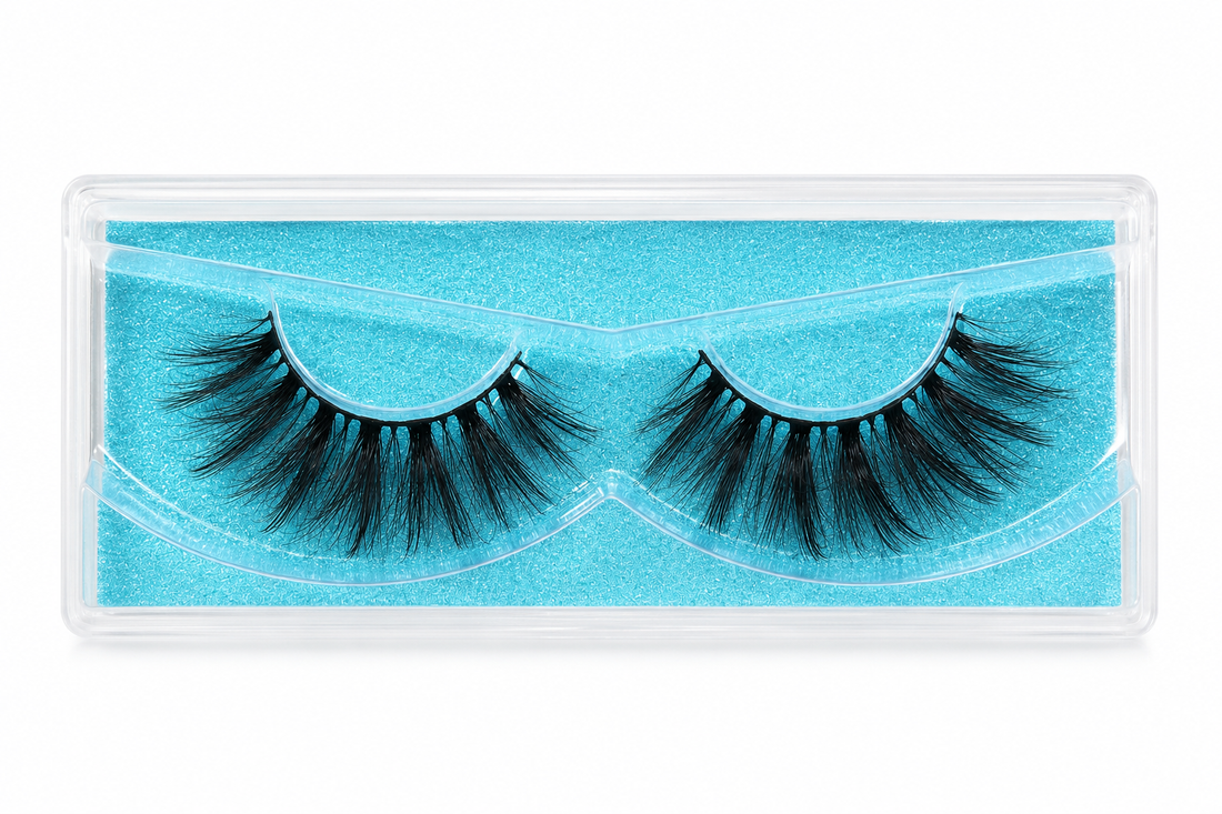 A pair of black false eyelashes in a clear plastic clamshell package with a bright turquoise blue insert, shown against a plain white background.