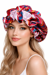 Woman wearing a colorful patterned shower cap on a white background