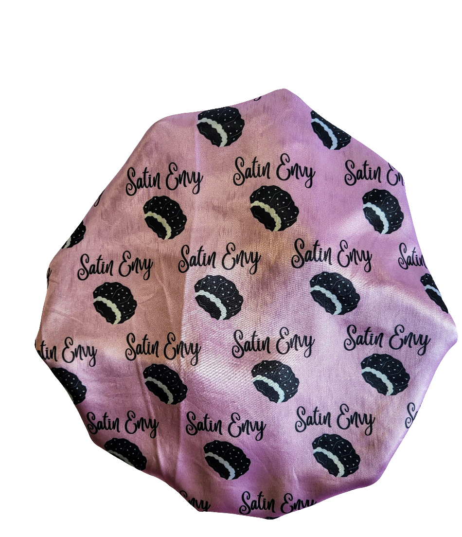 Satin Envy hair bonnet with black and white pattern on a pink background