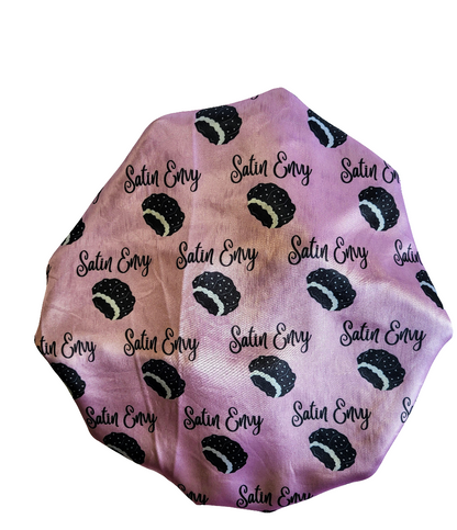 Satin Envy hair bonnet with black and white pattern on a pink background