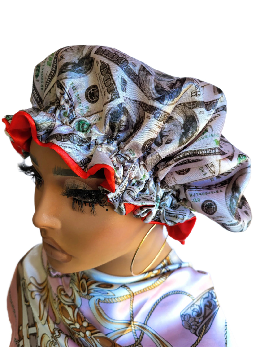A woman wearing a reversible sleeping satin hair bonnet with a wavy pattern and dollar bill design.
