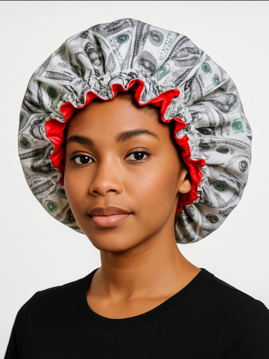 Person wearing a shower cap with money design on a plain background