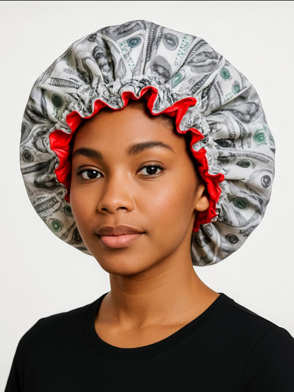 Person wearing a shower cap with money design on a plain background