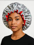 Person wearing a shower cap with money design on a plain background